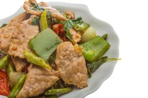 Pork with vegetables on the plate and white background photo