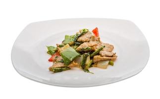 Pork with vegetables on the plate and white background photo