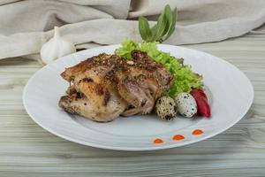 Quail grilled on the plate and wooden background photo