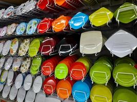 Rows of beautiful colorful plates lined up neatly on shopping mall shelves, can be used to serve dishes in culinary establishments such as restaurants. photo