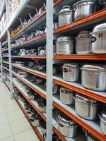 Jombang, East Java, Indonesia, 2022 - Rows of pan racks and various other kitchen utensils in supermarkets in Indonesia. portrait of display of household supplies in a shopping mall. photo
