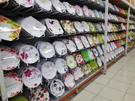 Rows of beautiful colorful plates lined up neatly on shopping mall shelves, can be used to serve dishes in culinary establishments such as restaurants. photo