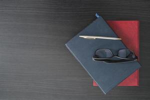 Glasses and book on the wood desk photo