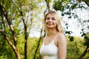 hermosa joven rubia en el bosque. la niña disfruta de la naturaleza foto