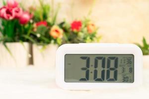 Digital clock with flora decorated on table photo