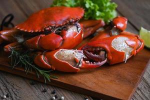 cangrejo de garra, cangrejo fresco en una tabla de cortar de madera mariscos cangrejo cocinar comida hervida o al vapor cangrejo rojo en la cocina del restaurante de mariscos