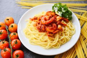 espaguetis a la boloñesa pasta italiana con camarones camarones servidos en un plato blanco con tomate perejil en el restaurante comida italiana y menú foto