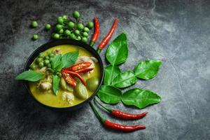 Thai food green curry on soup bowl with ingredient herb vegetable on dark plate background - green curry chicken cuisine asian food on the table photo