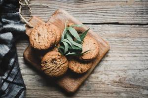 Cannabis food cookies with cannabis leaf marijuana herb on wooden background, delicious sweet dessert cookie with hemp leaf plant THC CBD herbs food snack and medical concept photo