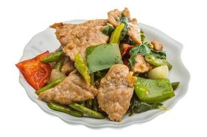 Pork with vegetables on the plate and white background photo