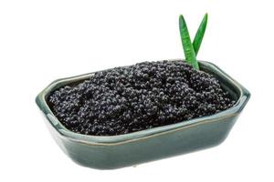 Black caviar in a bowl on white background photo