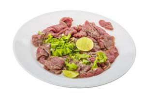 Beef carpaccio on the plate and white background photo