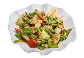 Pork with vegetables on the plate and white background photo