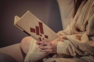 Close up of woman in bathrobe reading a book. photo