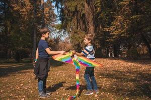 dos niños con una cometa jugando en el parque. foto