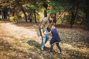 juguetona madre e hija divirtiéndose en el parque. foto