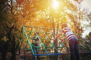 Two boys playing on the playground at the park. photo