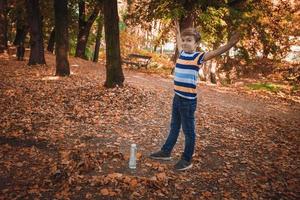 Little boy doing bottle flip in the park. photo