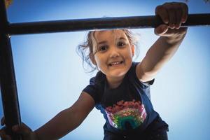 Below view of cute girl on jungle gym at the playground. photo