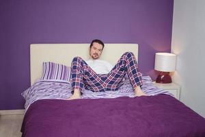 Thoughtful man relaxing on the bed. photo