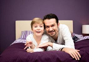 Loving father and son relaxing on the bed. photo