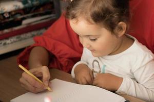 Mother is teaching daughter to write. photo