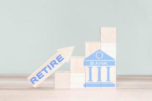 Wooden cube block with bank icon and wood arrow up with word retire. Retirement Planning Ideas. photo