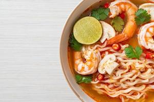 instant noodles ramen in spicy soup with shrimps - Tom Yum Kung photo