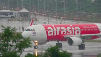 PHUKET, THAILAND DECEMBER 2, 2016 - Airbus 320 AirAsia HS BBH turn runway before departure on wet runway of Phuket airport. Rainy weather video