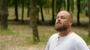 homem feliz em uma camisa branca no parque com barba video