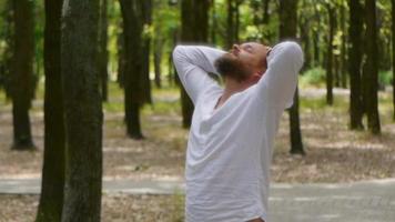 glücklicher Mann in einem weißen Hemd im Park mit Bart video