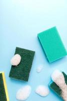 Multicolored sponges for cleaning on a blue background. Space for text. photo