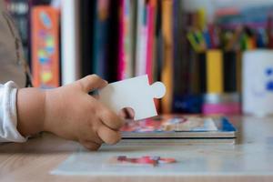 Close up of child playing with jigsaw puzzle. photo