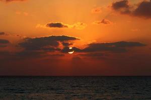 The sun sets below the horizon on the Mediterranean Sea in northern Israel. photo