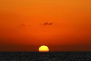 el sol se pone por debajo del horizonte en el mar mediterráneo en el norte de israel. foto