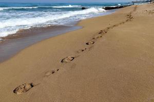 Footprints in the sand on the shores of the Mediterranean Sea. photo