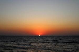 The sun sets below the horizon on the Mediterranean Sea in northern Israel. photo