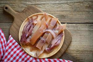 pickled squid on plate, raw squid for cooking food on wooden background, preserving food seafood photo