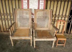 Old wooden chair classic on the front yard vintage style house in asia photo