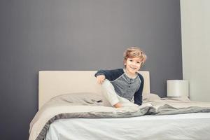 Happy little boy in bedroom. photo