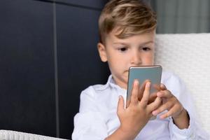 Close-up of kid playing games on smart phone. photo