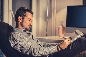 Businessman taking notes while working on new project in the evening. photo