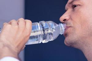 Close up of man drinking water. photo