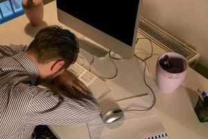 Above view of entrepreneur resting on office desk while working late. photo