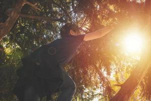 Below view of boy climbing on a tree. photo