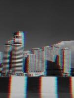 View of modern buildings from the street in the city background with glitch effect photo