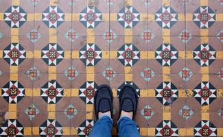 selfie de vista superior de pies en zapatillas de deporte en el fondo del piso vintage sin costuras con espacio de copia foto