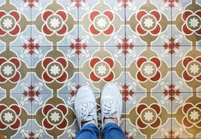 Top view selfie of feet in sneakers shoes on the vintage seamless floor background with copy space photo