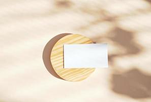 plano de la tarjeta de nombre comercial de identidad de marca sobre fondo de madera y amarillo, hojas con forma de luz y sombra, concepto mínimo para el diseño