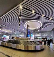 Istanbul, Turkey in July 2022. Tourists picking up their suitcases or luggage on a conveyor belt in the Istanbul international airport. photo